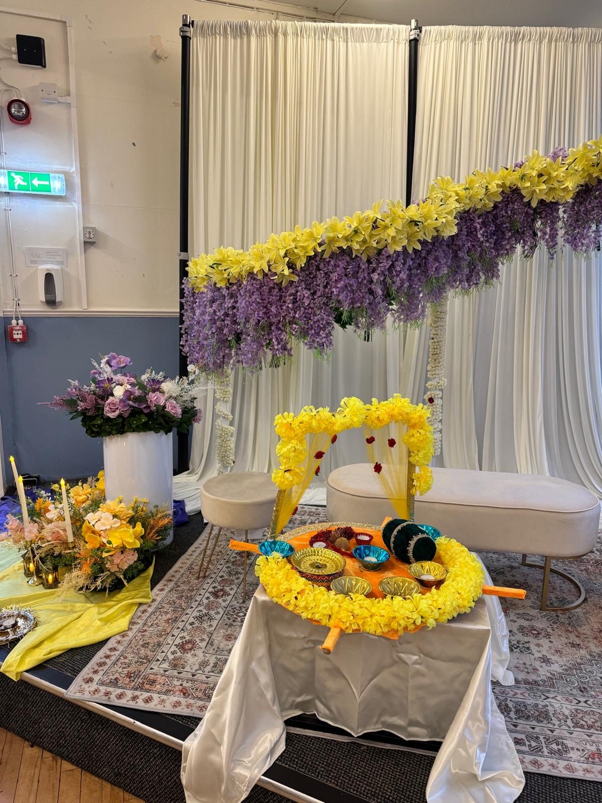 Haldi and mehndi stage with a cascading canopy of yellow and lilac florals