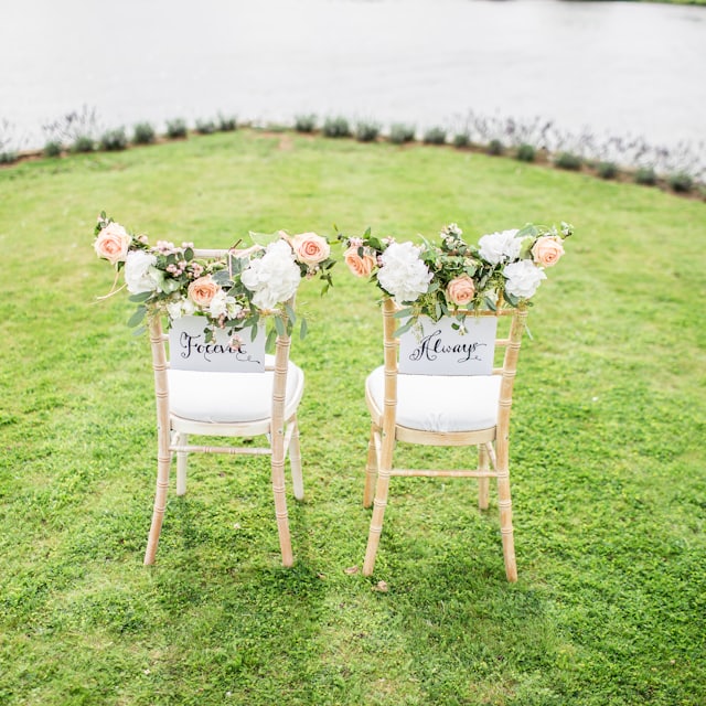 Ceremony chairs styled with florals on a garden lawn
