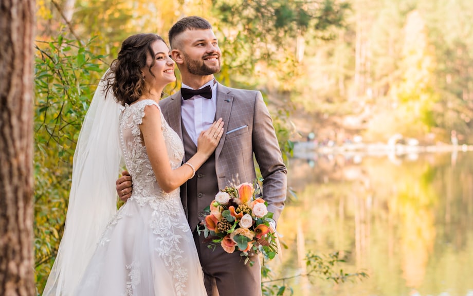 Couple walking through golden autumn woodland