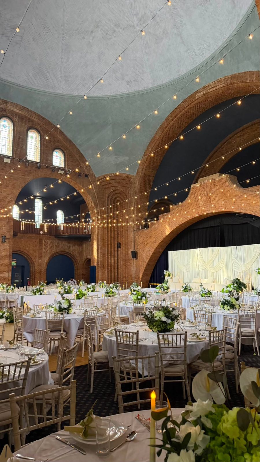 Reception styled beneath grand brick arches strung with festoon lights